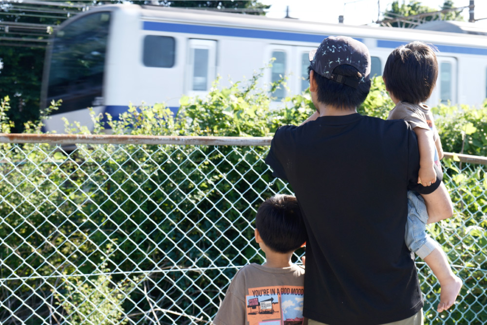 線路沿いのロケーションを活かした敷地に立つ、個性的な間取りで広がりを演出したシンプルな平屋